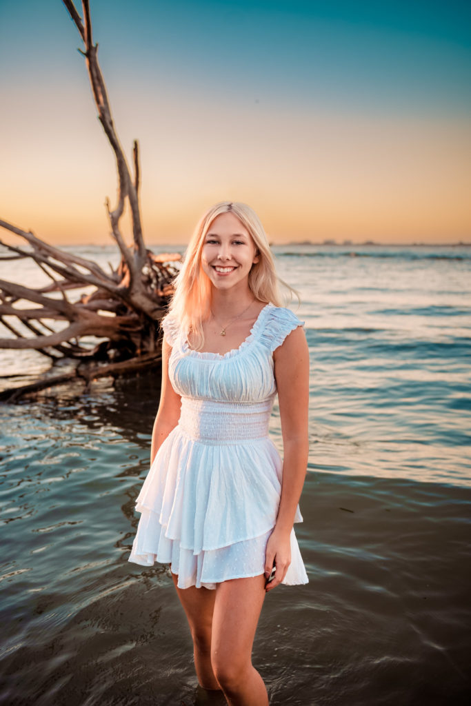 Senior Girl in the water on the beach for graduation pictures
